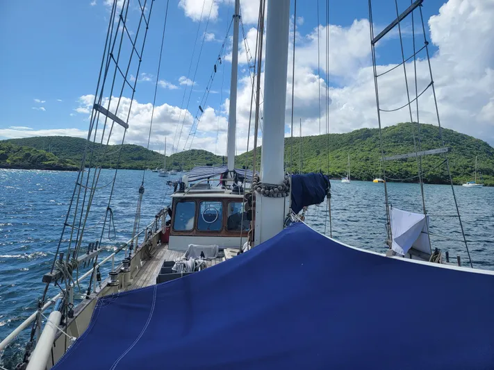 Maisie Rose Yacht Photos Pics Sailing yacht "Kuipper NV Holland" 1984 on scenic water with lush green hills.