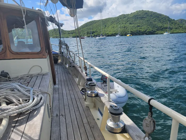 Maisie Rose Yacht Photos Pics Sailing yacht "Kuipper NV Holland" 1984 on scenic water with lush green hills.