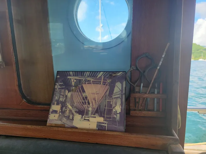 Maisie Rose Yacht Photos Pics Framed shipbuilding photo on wooden shelf, Custom Kuipper NV Holland, 1984, with tools and porthole view.