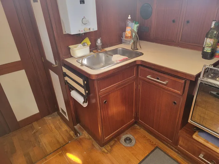 Maisie Rose Yacht Photos Pics 1984 Kuipper NV Holland custom kitchen with wooden cabinets and stainless steel sink.