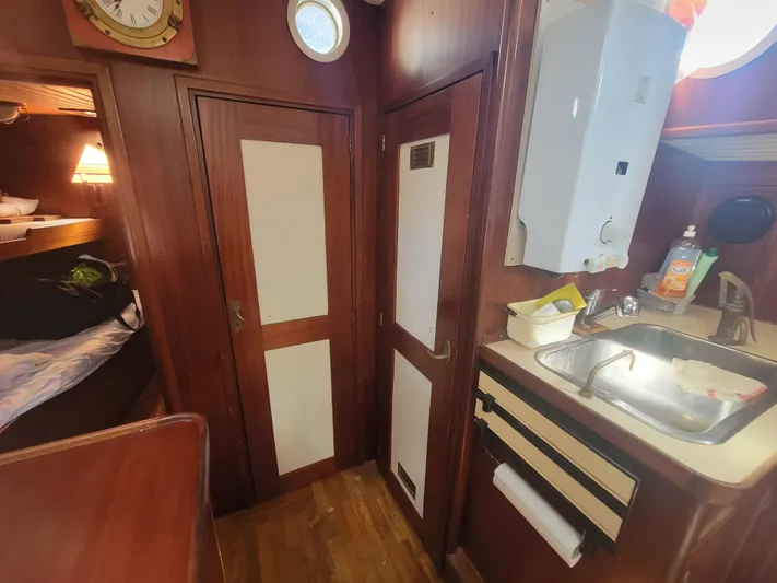 Maisie Rose Yacht Photos Pics 1984 Kuipper NV Holland boat interior with wood paneling, sink, and cozy sleeping area.