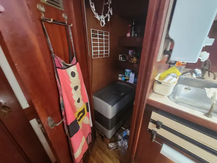 Maisie Rose Yacht Photos Pics Compact 1984 Kuipper NV Holland boat interior with storage, sink, and colorful apron.