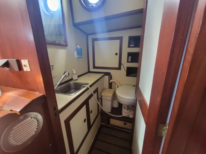 Maisie Rose Yacht Photos Pics Compact 1984 Kuipper NV Holland boat bathroom with sink, toilet, and wooden accents.