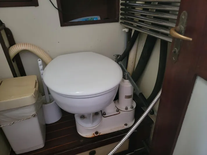 Maisie Rose Yacht Photos Pics 1984 Kuipper NV Holland marine toilet with manual pump in compact bathroom setting.