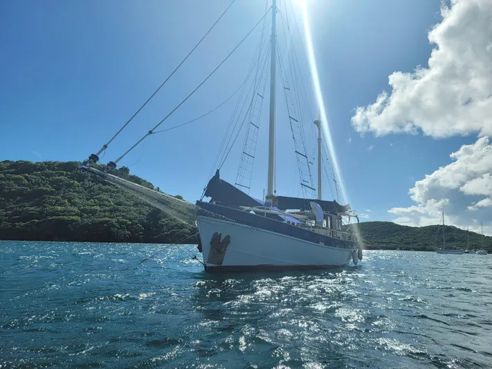 Maisie Rose Yacht Photos Pics Sailing yacht "Kuipper NV Holland" 1984 on sunny waters near lush green hills.