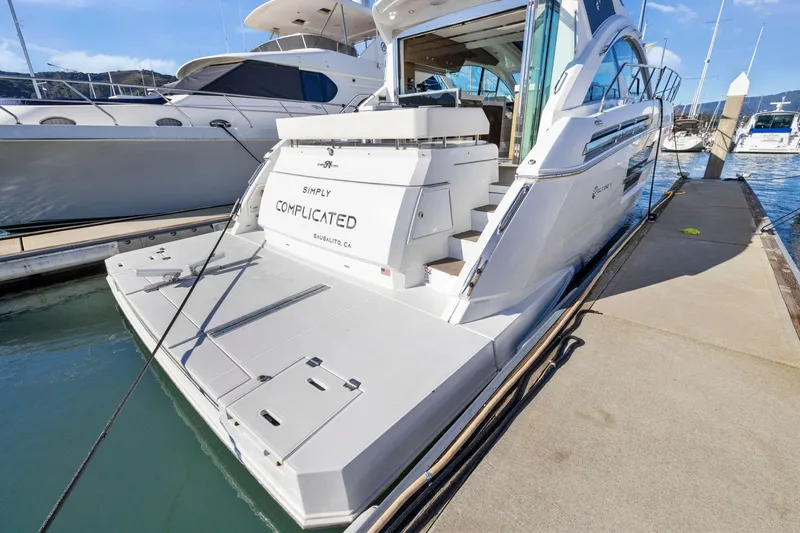 Simply Complicated Yacht Photos Pics 2019 Cruisers Yachts 54 Cantius docked, rear view with "Simply Complicated" name visible.