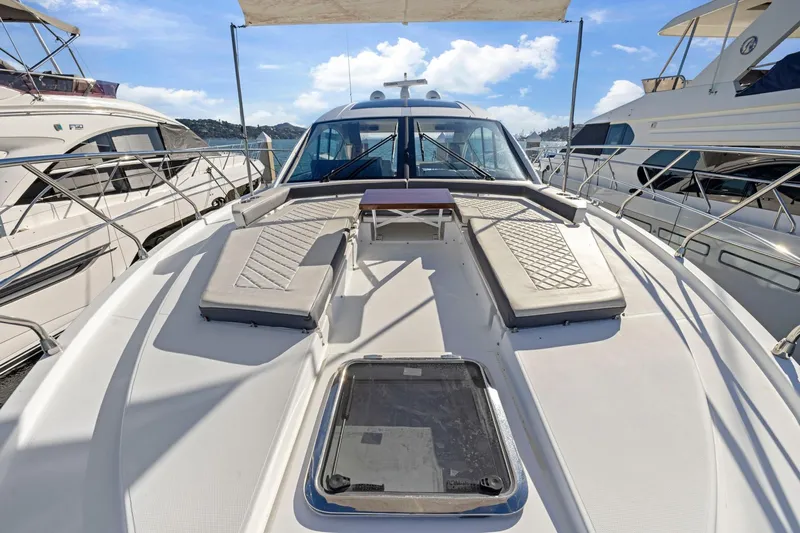 Simply Complicated Yacht Photos Pics 2019 Cruisers Yachts 54 Cantius with sunbathing deck, docked among other luxury boats.