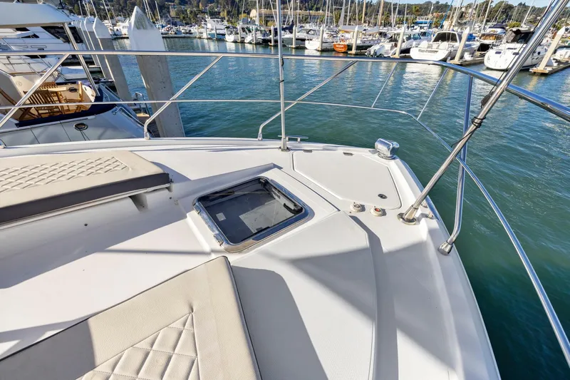 Simply Complicated Yacht Photos Pics Bow view of 2019 Cruisers Yachts 54 Cantius at marina, showcasing deck and railing.