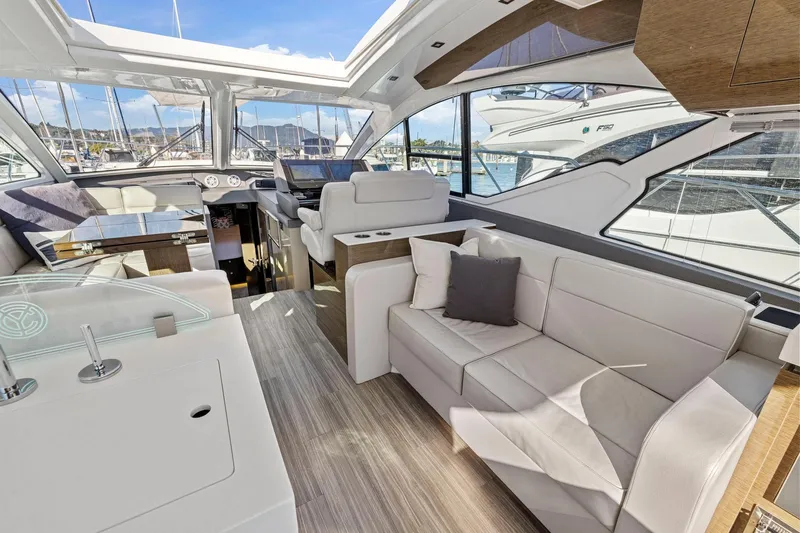 Simply Complicated Yacht Photos Pics Luxurious interior of 2019 Cruisers Yachts 54 Cantius with modern seating and panoramic windows.