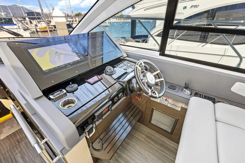 Simply Complicated Yacht Photos Pics 2019 Cruisers Yachts 54 Cantius helm with modern navigation displays and steering wheel.
