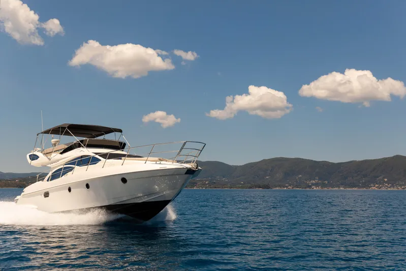 Shine IV Yacht Photos Pics 2006 Azimut 43 yacht cruising on open water under a clear blue sky.