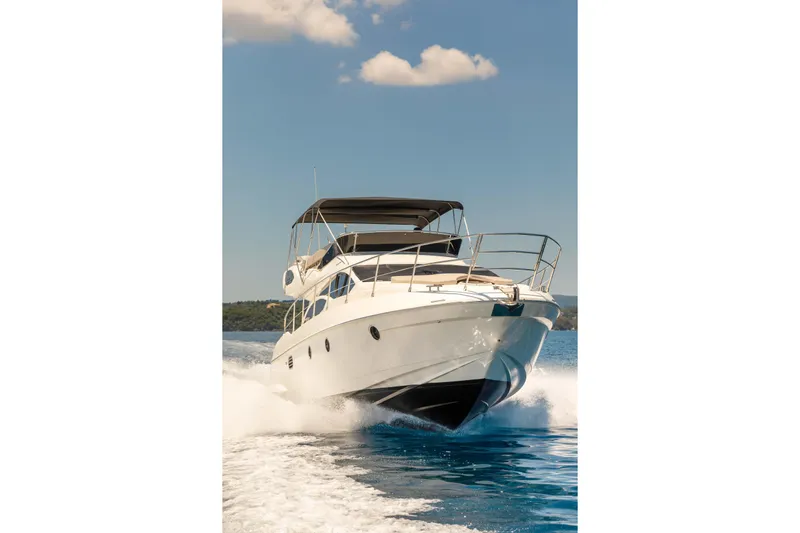 Shine IV Yacht Photos Pics 2006 Azimut 43 yacht cruising on open water under a clear blue sky.