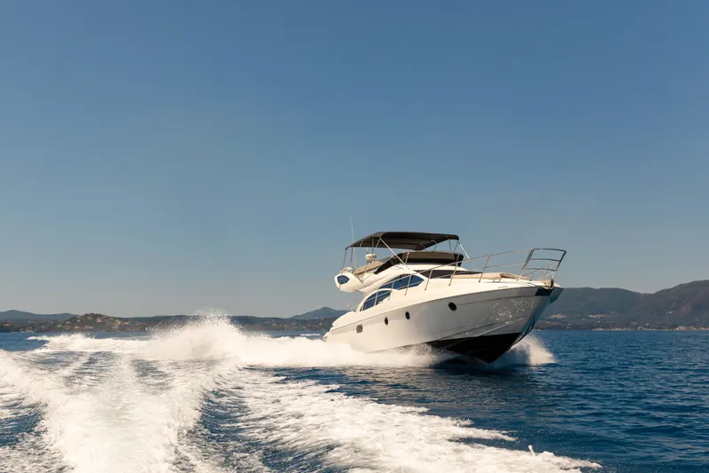 Shine IV Yacht Photos Pics 2006 Azimut 43 yacht cruising on open water with scenic mountain backdrop.