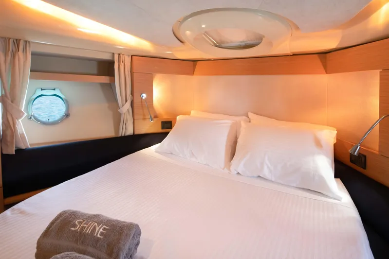 Shine IV Yacht Photos Pics Luxurious bedroom interior of 2006 Azimut 43 yacht with cozy bedding and porthole view.