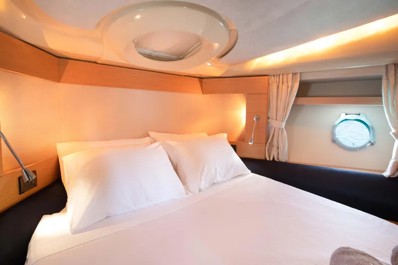 Shine IV Yacht Photos Pics Luxurious bedroom interior of 2006 Azimut 43 yacht with cozy bedding and porthole view.