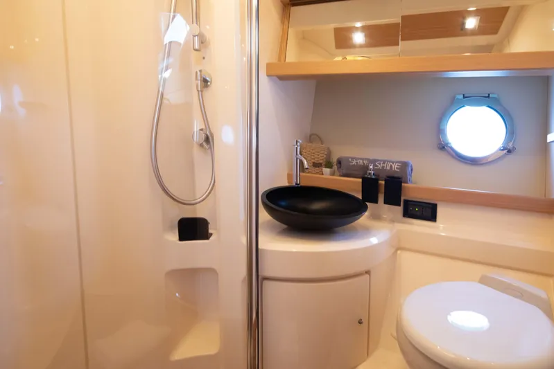 Shine IV Yacht Photos Pics Luxurious bathroom in 2006 Azimut 43 yacht with modern fixtures and porthole window.