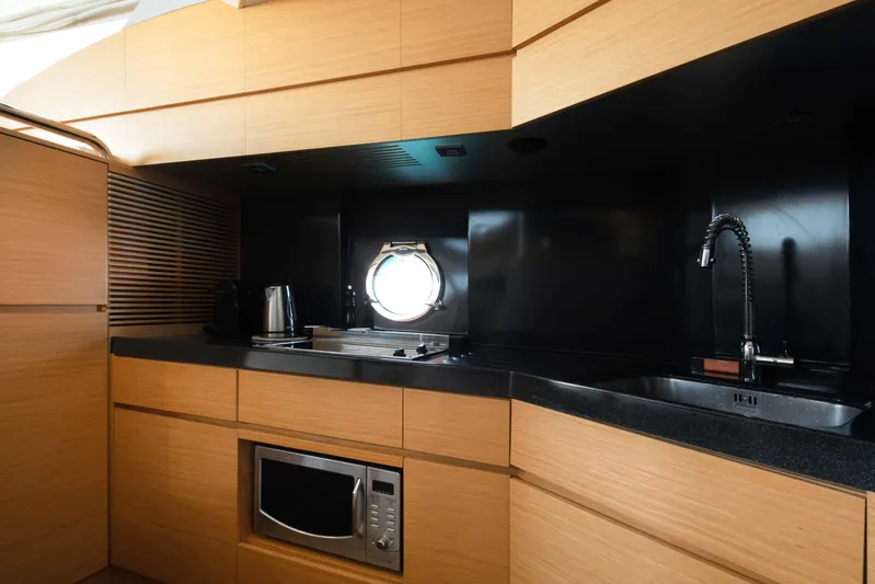 Shine IV Yacht Photos Pics Modern kitchen interior of 2006 Azimut 43 yacht with sleek wood cabinetry and appliances.