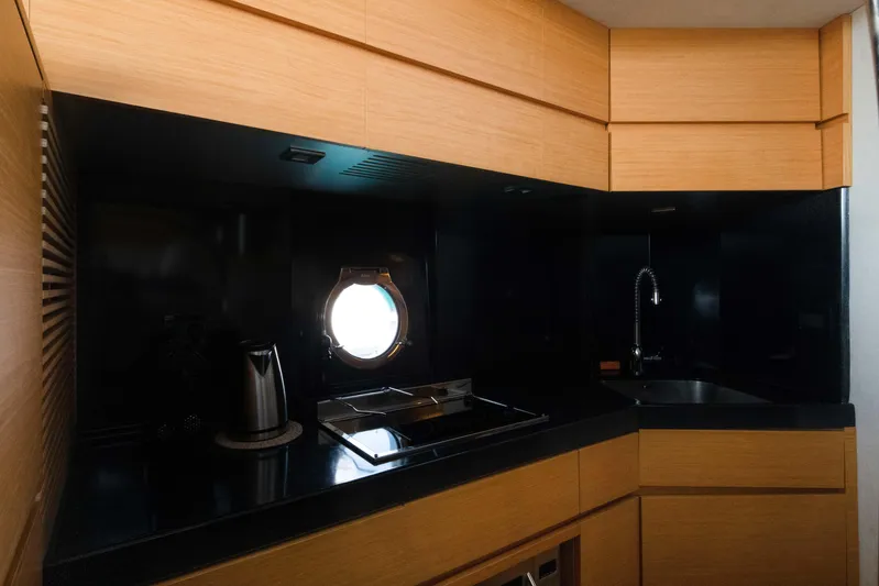 Shine IV Yacht Photos Pics Luxurious 2006 Azimut 43 yacht kitchen with modern appliances and sleek wood cabinetry.