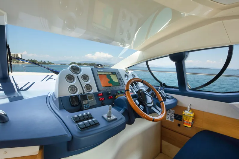 Shine IV Yacht Photos Pics 2006 Azimut 43 yacht helm with navigation controls, steering wheel, and sea view.