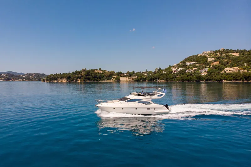 Shine IV Yacht Photos Pics 2006 Azimut 43 yacht cruising on serene blue waters near a scenic coastline.