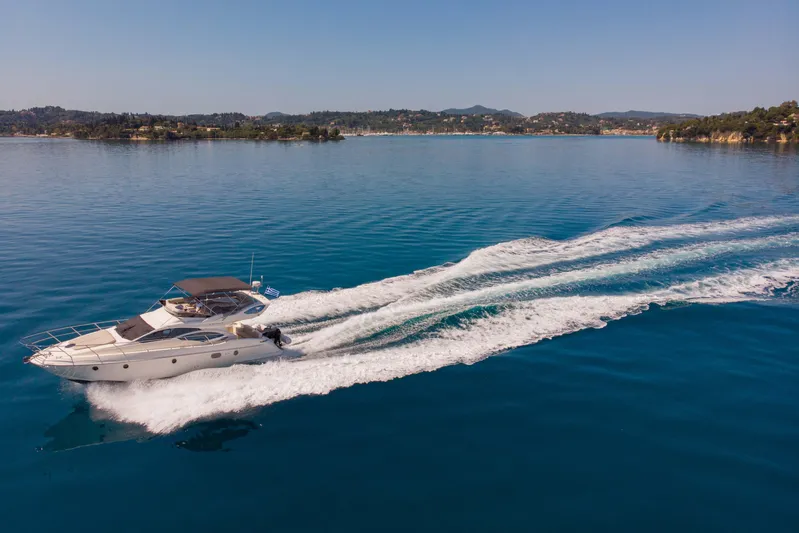 Shine IV Yacht Photos Pics 2006 Azimut 43 yacht cruising on calm blue waters near a scenic coastline.