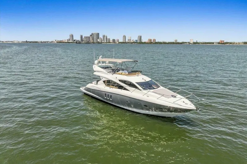Cheers Yacht Photos Pics 2009 Sunseeker Manhattan 52 yacht on open water with city skyline backdrop.