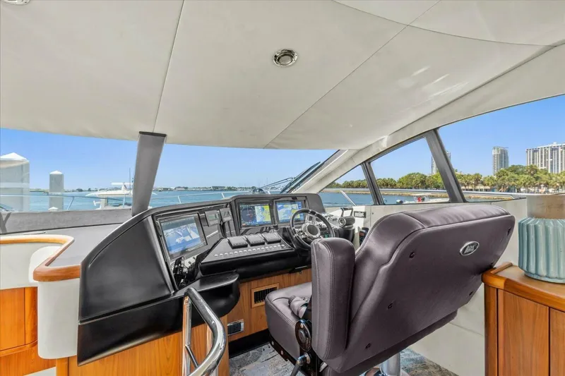 Cheers Yacht Photos Pics 2009 Sunseeker Manhattan 52 yacht helm with modern controls and waterfront view.