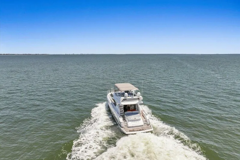 Cheers Yacht Photos Pics 2009 Sunseeker Manhattan 52 yacht cruising on open water under clear blue sky.