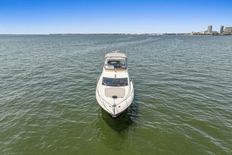 Cheers Yacht Photos Pics 2009 Sunseeker Manhattan 52 yacht on open water, distant city skyline.