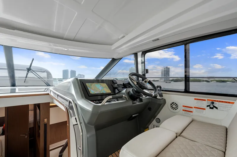 Notre Reve Yacht Photos Pics Helm of 2018 Jeanneau Leader 46 yacht with modern navigation system and city skyline view.