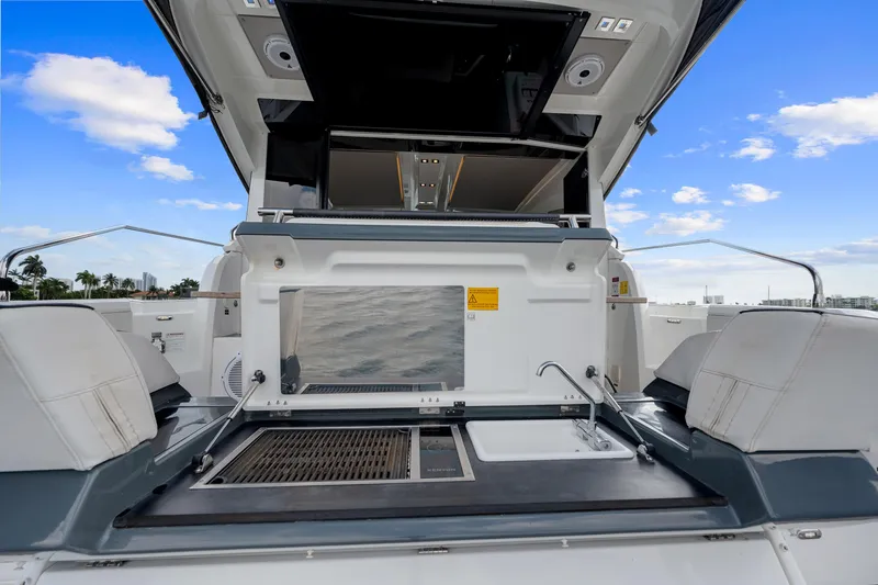 Notre Reve Yacht Photos Pics 2018 Jeanneau Leader 46 yacht with outdoor kitchen and seating, under a clear blue sky.