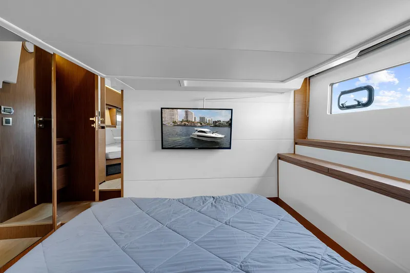 Notre Reve Yacht Photos Pics Interior cabin of 2018 Jeanneau Leader 46 yacht with bed and wall-mounted TV.