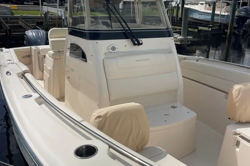  Yacht Photos Pics 2022 Grady-White Canyon 271 boat interior with seating and console, docked at marina.