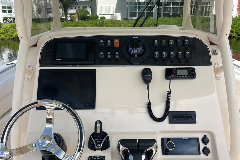  Yacht Photos Pics 2022 Grady-White Canyon 271 boat dashboard with steering wheel and electronic controls.