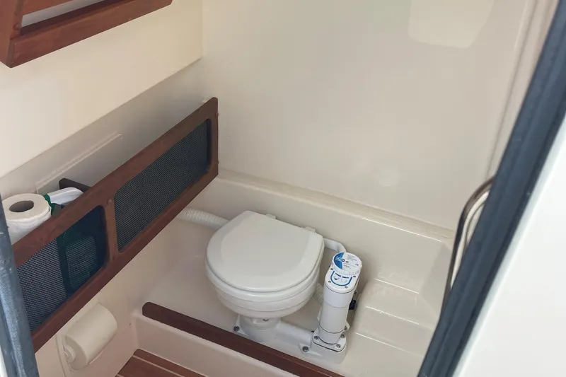  Yacht Photos Pics 2022 Grady-White Canyon 271 boat bathroom with toilet and storage shelves.