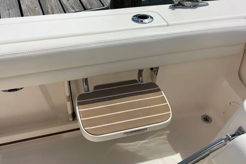 Yacht Photos Pics 2022 Grady-White Canyon 271 boat with a foldable wooden step and white seating.