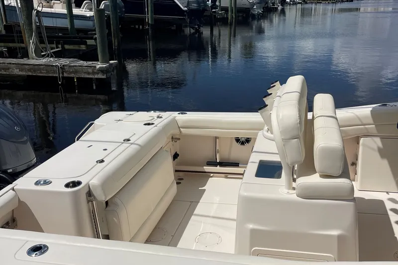  Yacht Photos Pics 2022 Grady-White Canyon 271 boat interior with seating, docked by calm water.