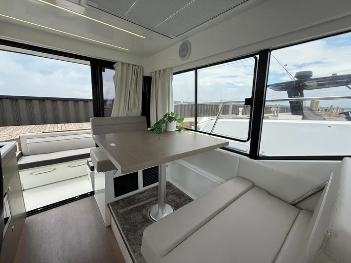  Yacht Photos Pics 2024 Jeanneau NC Weekender 895 Series 2 interior with dining area and panoramic windows.