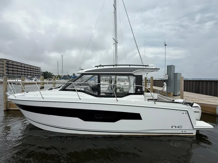  Yacht Photos Pics 2024 Jeanneau NC Weekender 895 Series 2 docked at marina under cloudy sky.