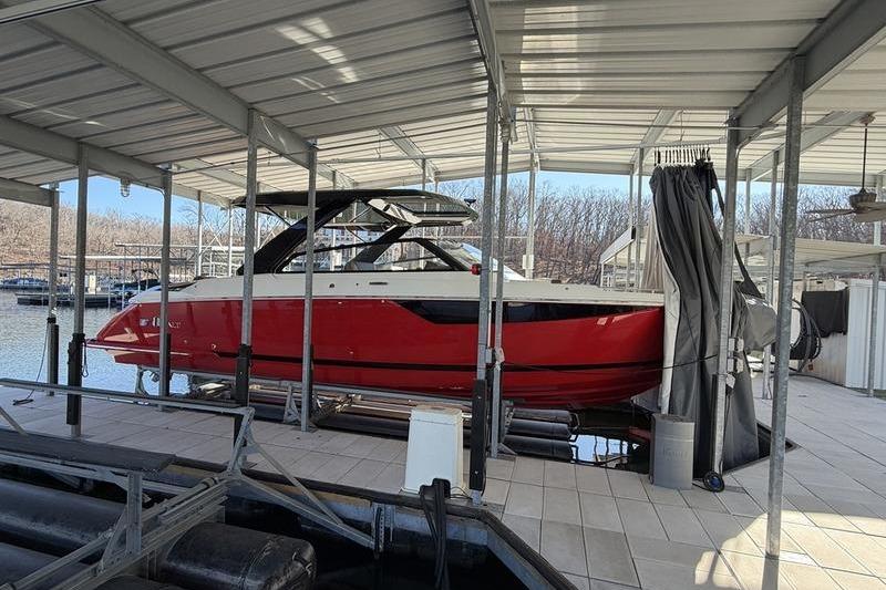 2025 Cobalt R35 boat in a covered dock, featuring a sleek red and white design.