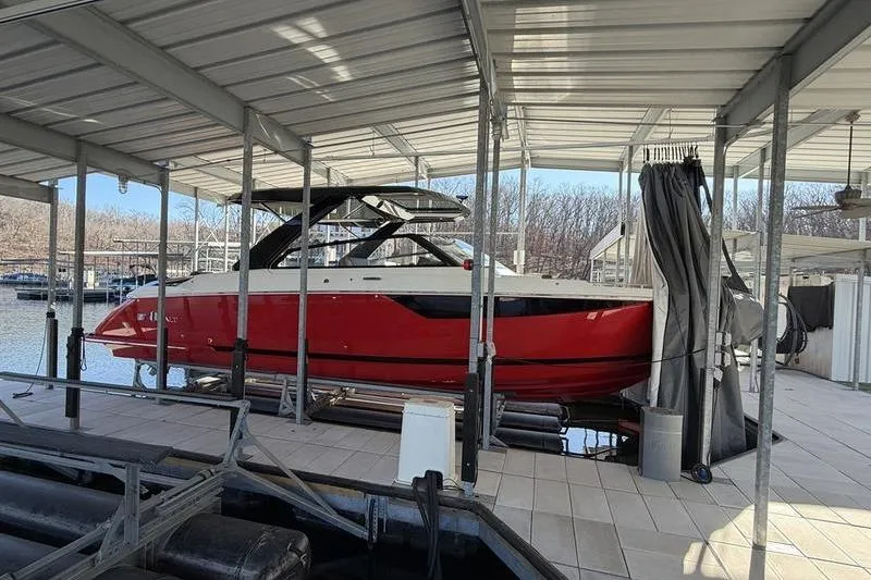 2025 Cobalt R35 boat in a covered dock, featuring a sleek red and white design.