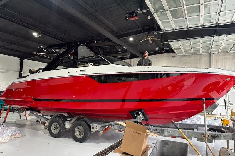 2025 Cobalt R35 boat in a garage, vibrant red hull on a trailer.