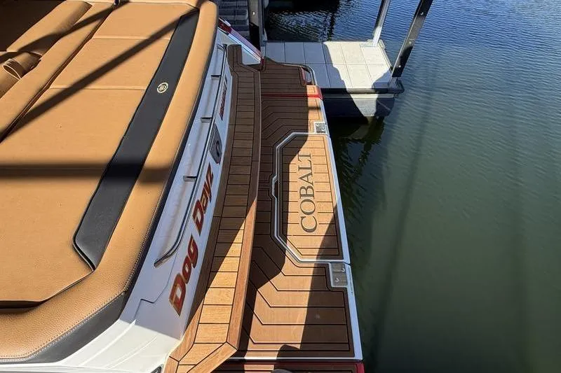 2025 Cobalt R35 boat with tan seating and wooden deck by the water.