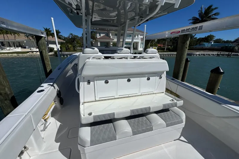 Reel Advice Yacht Photos Pics 2019 Invincible 39 Open Fisherman boat interior with seating and storage, docked by waterfront homes.