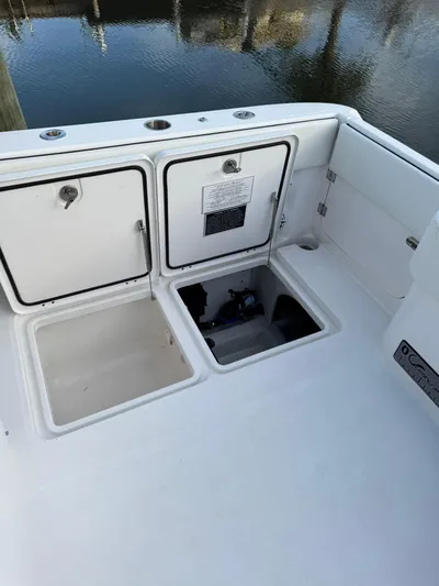  Yacht Photos Pics 2023 Invincible 33 Catamaran deck with open storage compartments by the water.