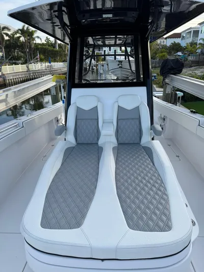  Yacht Photos Pics 2023 Invincible 33 Catamaran with luxurious seating and sleek design in a marina setting.