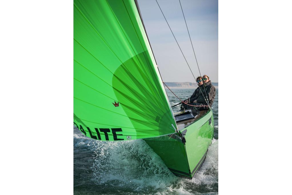 Saffier 24 Lite 2026 sailboat with vibrant green sail navigating ocean waters.