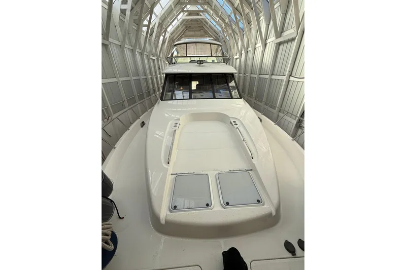  Yacht Photos Pics 1997 Bayliner 5788 Pilot House Motoryacht in a covered dock, showcasing sleek design.