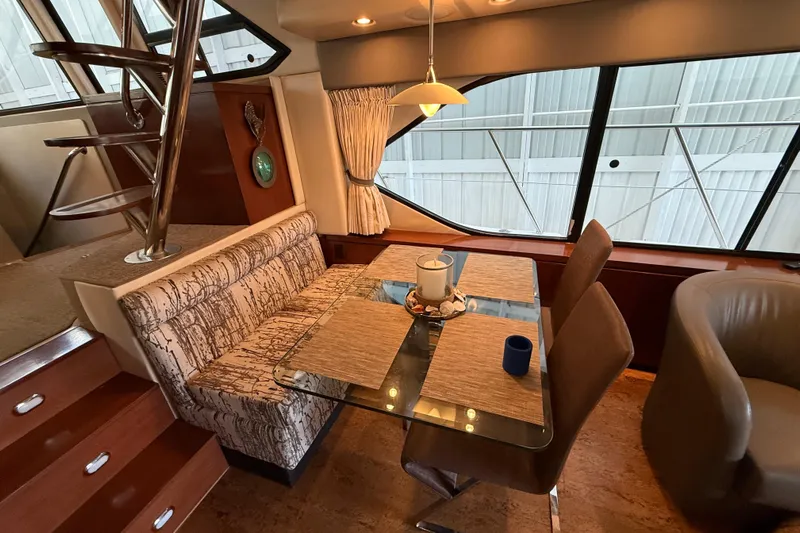  Yacht Photos Pics Interior of 1997 Bayliner 5788 Pilot House Motoryacht with dining area and spiral staircase.