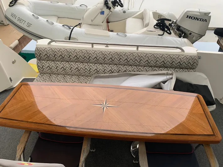  Yacht Photos Pics 1997 Bayliner Pilothouse with wooden table and Honda motorboat in background.